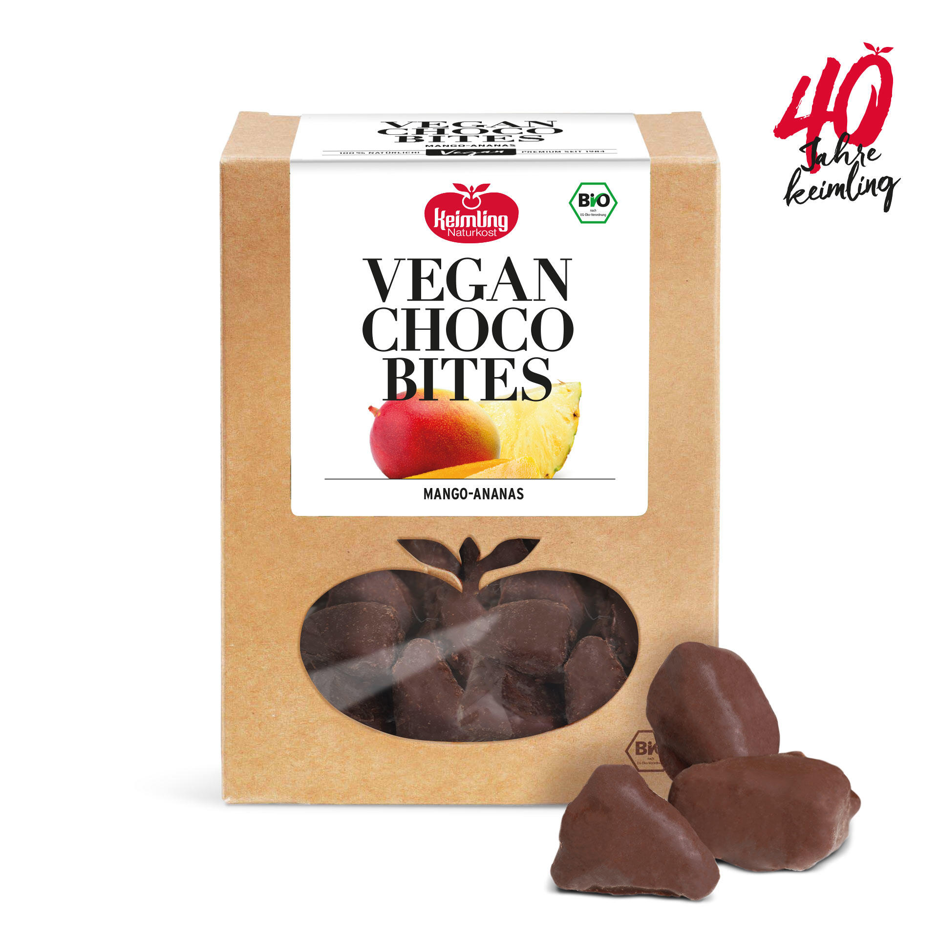 Die Verpackung zeigt Vegan Choco Bites Mango-Ananas von Keimling mit Bio-Siegel. Drei schokoladenüberzogene Fruchtstücke liegen daneben. Text 40 Jahre keimling rechts oben.