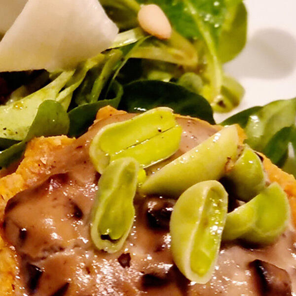 Miso Pilz Quiche von Boris Lauser Nahaufnahme einer veganen Miso-Pilz-Quiche mit grünen Bohnenhälften und frischem Salat im Hintergrund.