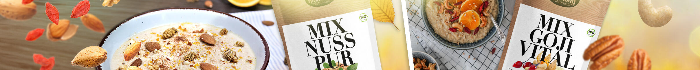 Zwei Packungen Keimling Bio Nuss-Mixe, eine mit der Aufschrift Mix Nuss Pur und die andere Mix Goji Vital, sind sichtbar, umgeben von verschiedenen Nüssen und Trockenfrüchten.