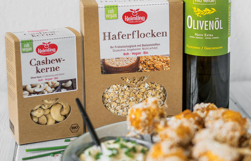 Ein eleganter Tisch mit einer Flasche Olivenöl, einer Schachtel Nüssen und einer Schüssel Crackern, perfekt für die Gesunde Küche.