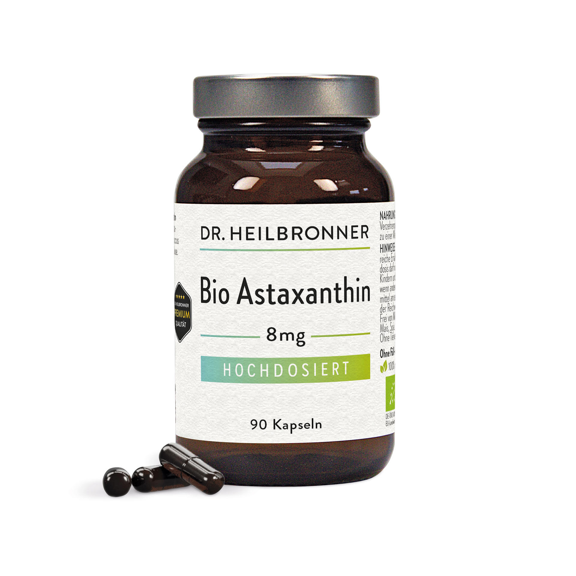 Braunes Glasfläschchen mit silbernem Deckel, beschriftet mit Dr. Heilbronner Bio Astaxanthin 8 mg Hochdosiert 90 Kapseln. Mehrere schwarze Kapseln liegen davor.