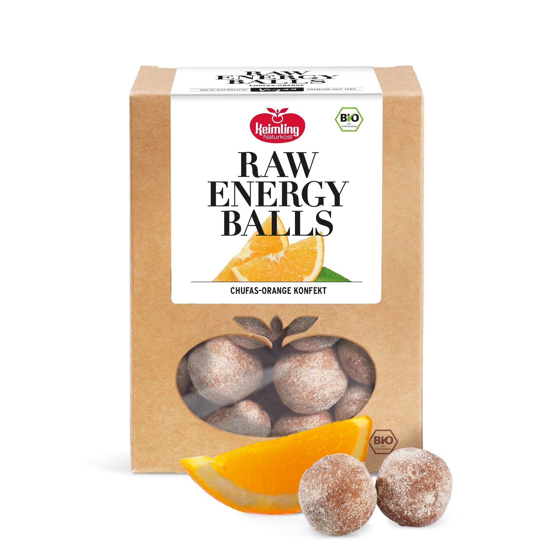Verpackung einer Keimling Naturkost Raw Energy Balls Chufas-Orange mit Sichtfenster und zwei braunen Energy Balls sowie einer Orangenscheibe davor.