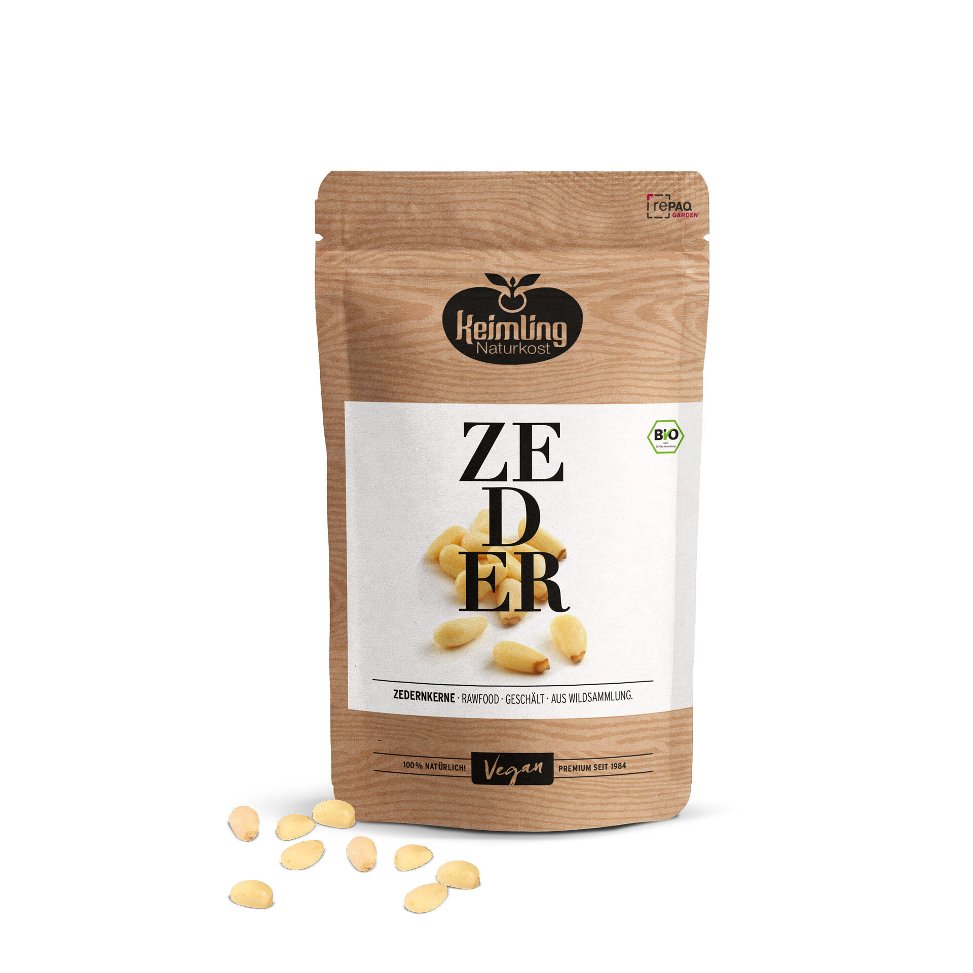 Keimling Naturkost Verpackung mit Zedernkernen. Die Nüsse liegen teilweise vor der Packung. Auf der Verpackung steht: ZEDERNKERN und ZEDERNKERNE · RAWFOOD · GESCHÄLT · AUS WILDSAMMLUNG. Bio- und Vegan-Label sind sichtbar.