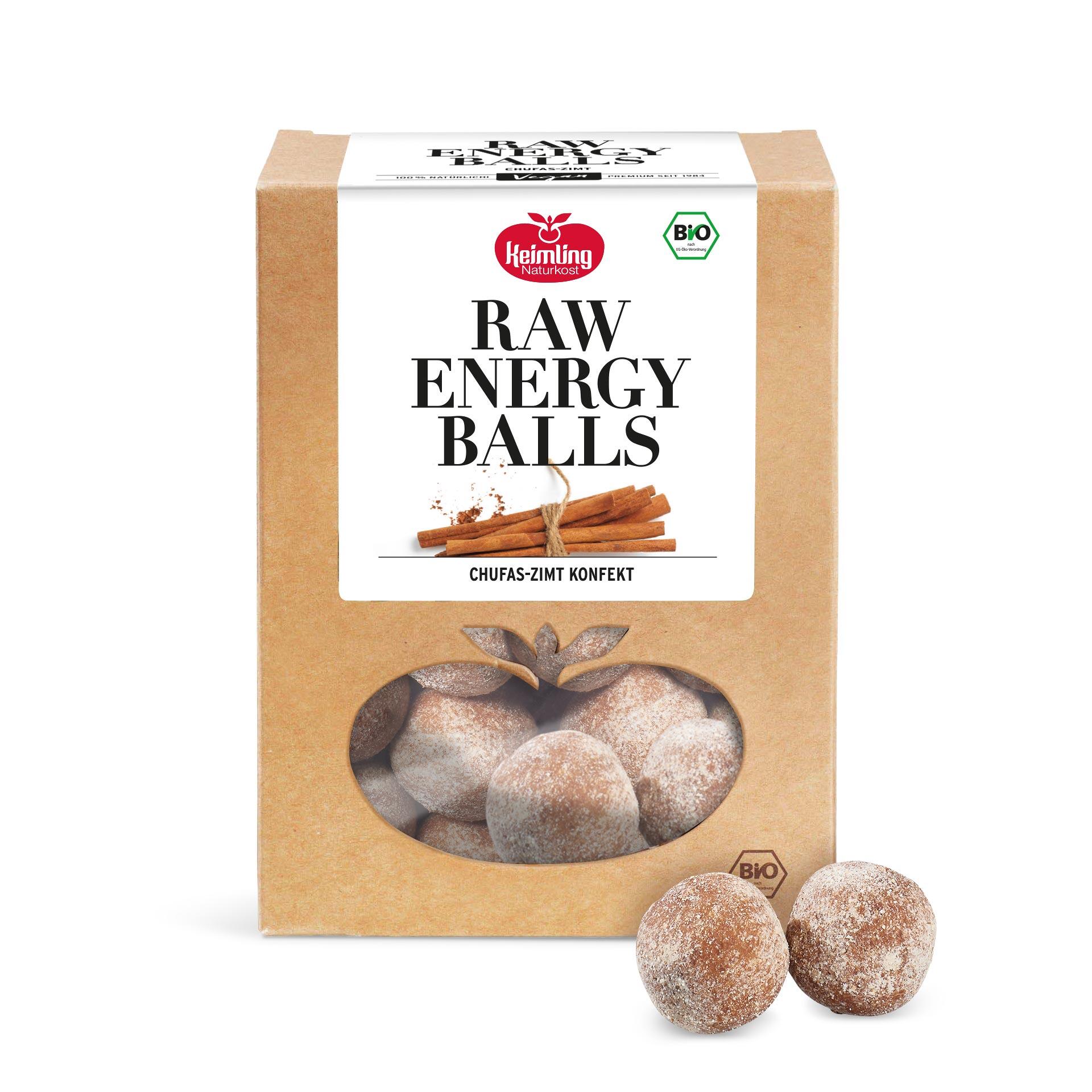 Verpackung der Keimling Naturkost Raw Energy Balls mit Chufas-Zimt Geschmack. Die Verpackung zeigt gerollte Zimtstangen und einen Bio-Siegel. Zwei braune energy balls mit Puderzucker liegen daneben.