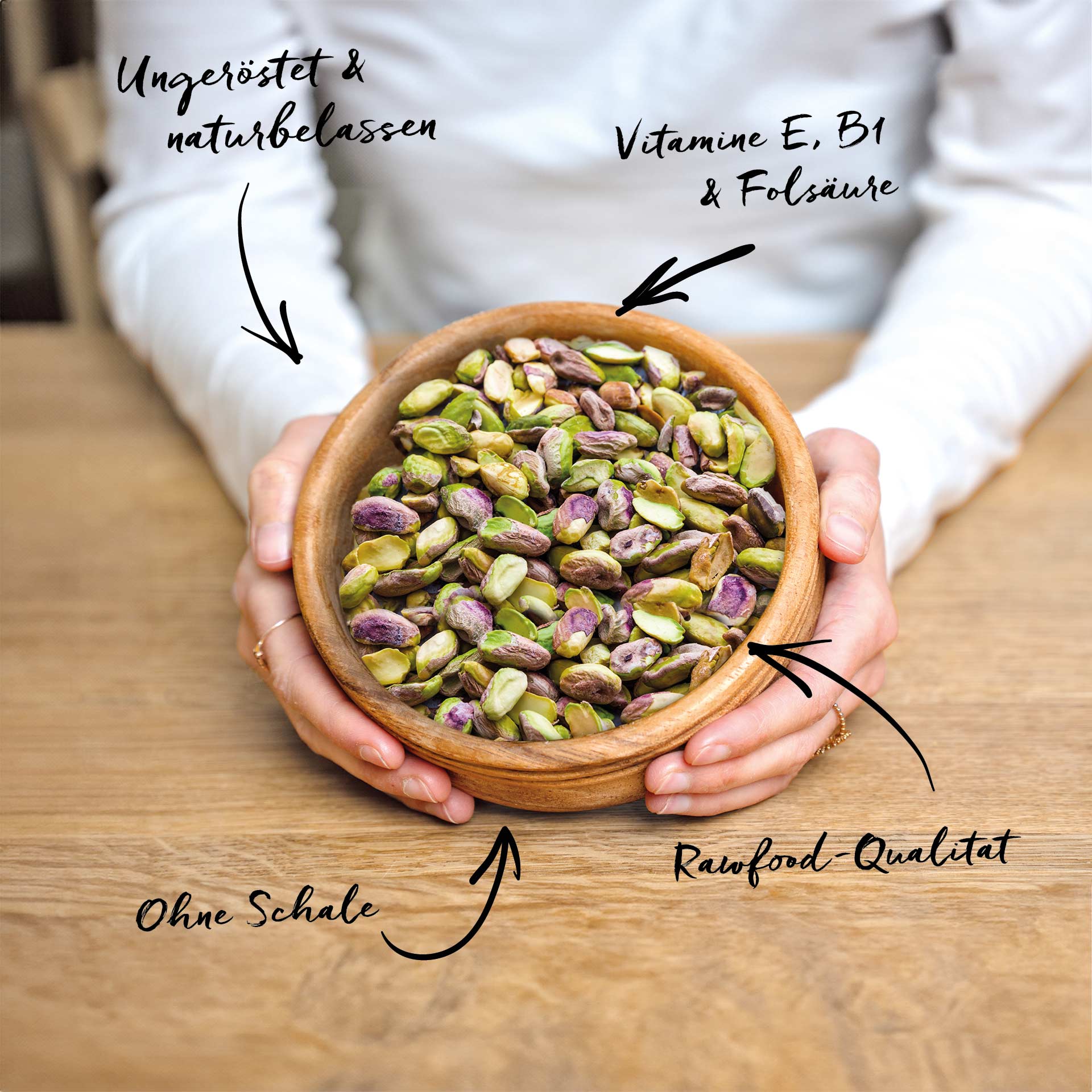 Pistazien, geschält, bio 1 kg Eine Person hält eine Holzschale mit ungerösteten und naturbelassenen Pistazien ohne Schale. Auf dem Bild stehen die Texte: Ungeröstet & naturbelassen, Vitamine E, B1 & Folsäure und Rawfood-Qualität.