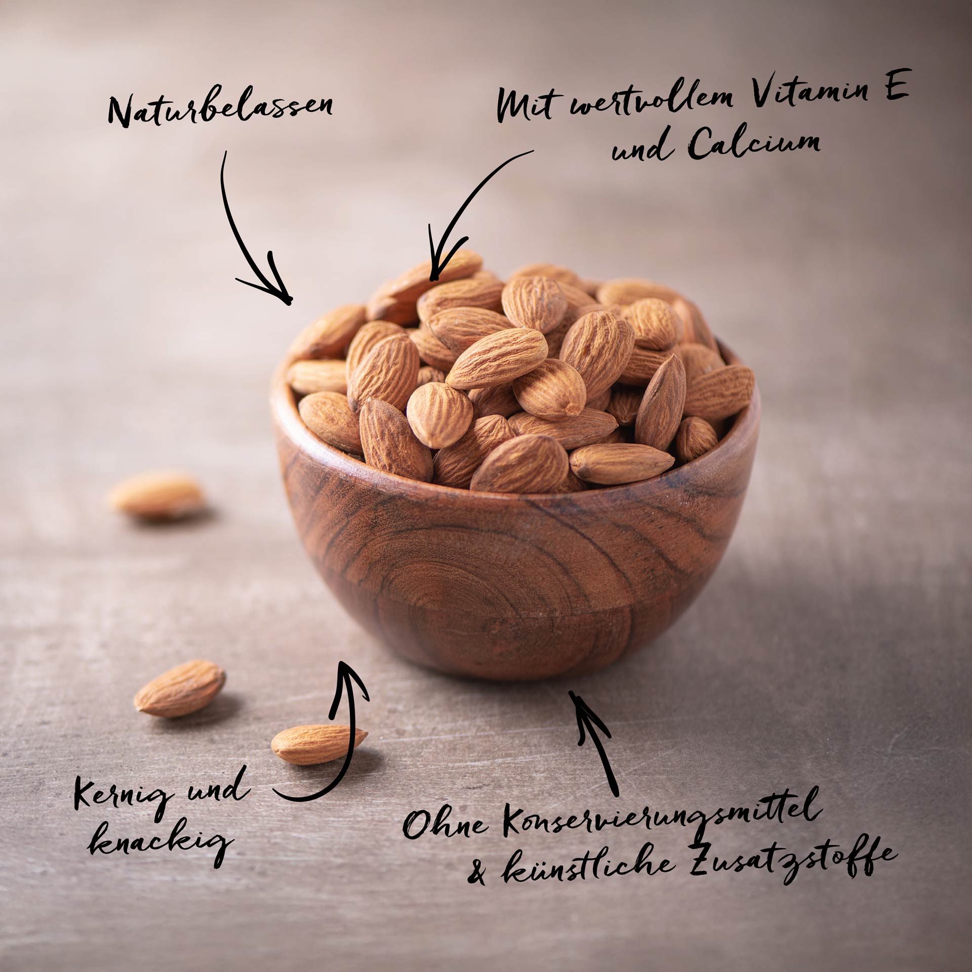 Mandeln, bio 200 g Eine Holzschale enthält naturbelassene Mandeln. Pfeile mit Text zeigen: Naturbelassen, Mit wertvollem Vitamin E und Calcium, Kernig und knackig und Ohne Konservierungsmittel & künstliche Zusatzstoffe.
