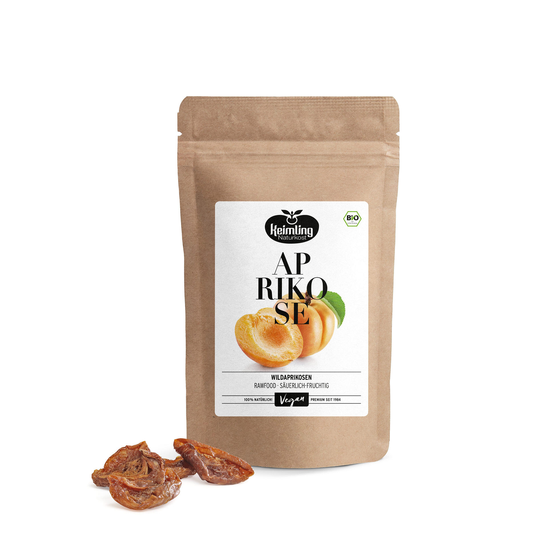 Eine braune Verpackung mit dem Etikett Keimling Naturkost Aprikose. Drei getrocknete Aprikosen liegen vorne. Auf dem Etikett steht Wildaprikosen Rawfood - Säuerlich-Fruchtig Vegan 100% Natürlich Premium seit 1984.